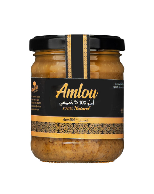 A glass jar of Amlou spread with a black lid and a black label featuring gold text and patterns, set against a plain white background.