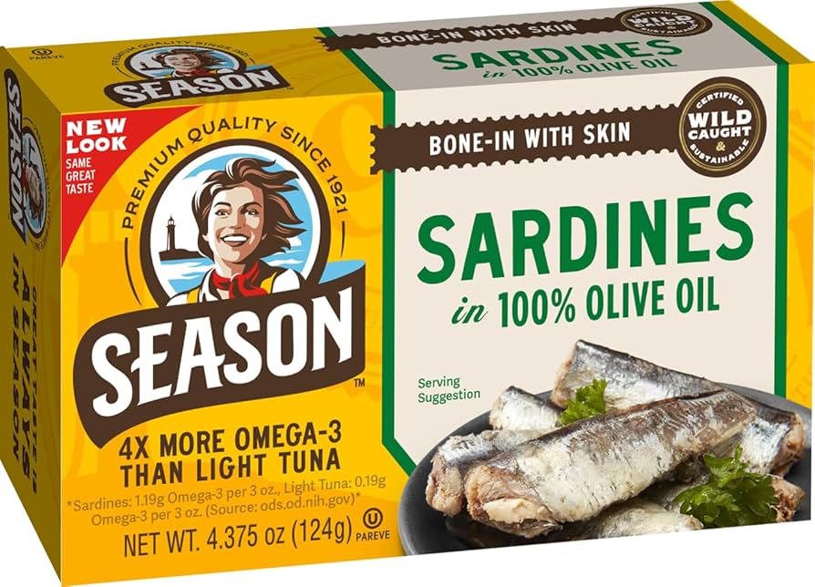 A box of Season brand Sardines in 100% Olive Oil, featuring a yellow and white packaging design with green accents, a cartoon illustration of a man, and a photo of cooked sardines on the front.