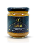 A glass jar of Amlou honey with a black lid and a dark navy label featuring gold text and a bee logo, set against a plain white background.