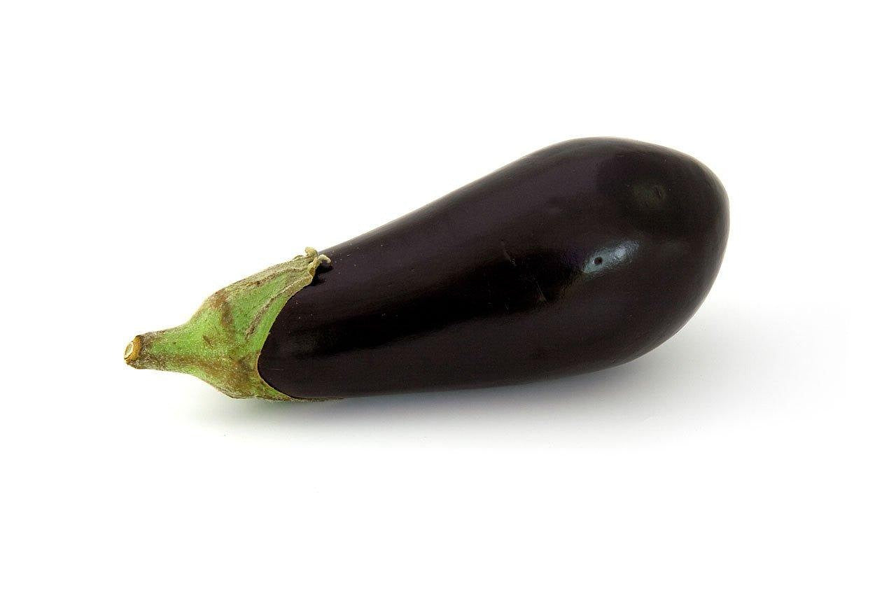 A single dark purple eggplant with a green stem, photographed on a clean white background.