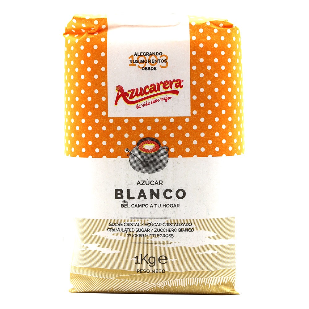 A 1 kg bag of Azucarera brand white sugar, featuring a bright orange and white polka dot pattern on the top half, a white center label with the red 'Azucarera' logo, and a light beige textured bottom half.