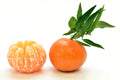 A whole orange with green leaves and a peeled orange segment, photographed on a clean white background.