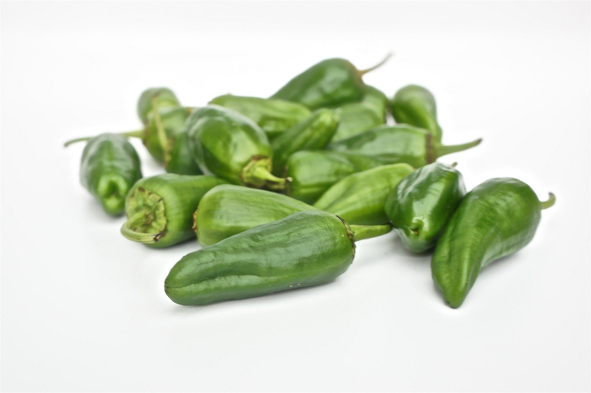 Green padron peppers on a white background