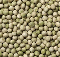 A close-up, top-down view of numerous light green and off-white peas filling the entire frame.