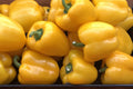 Yellow bell peppers displayed in wooden crates
